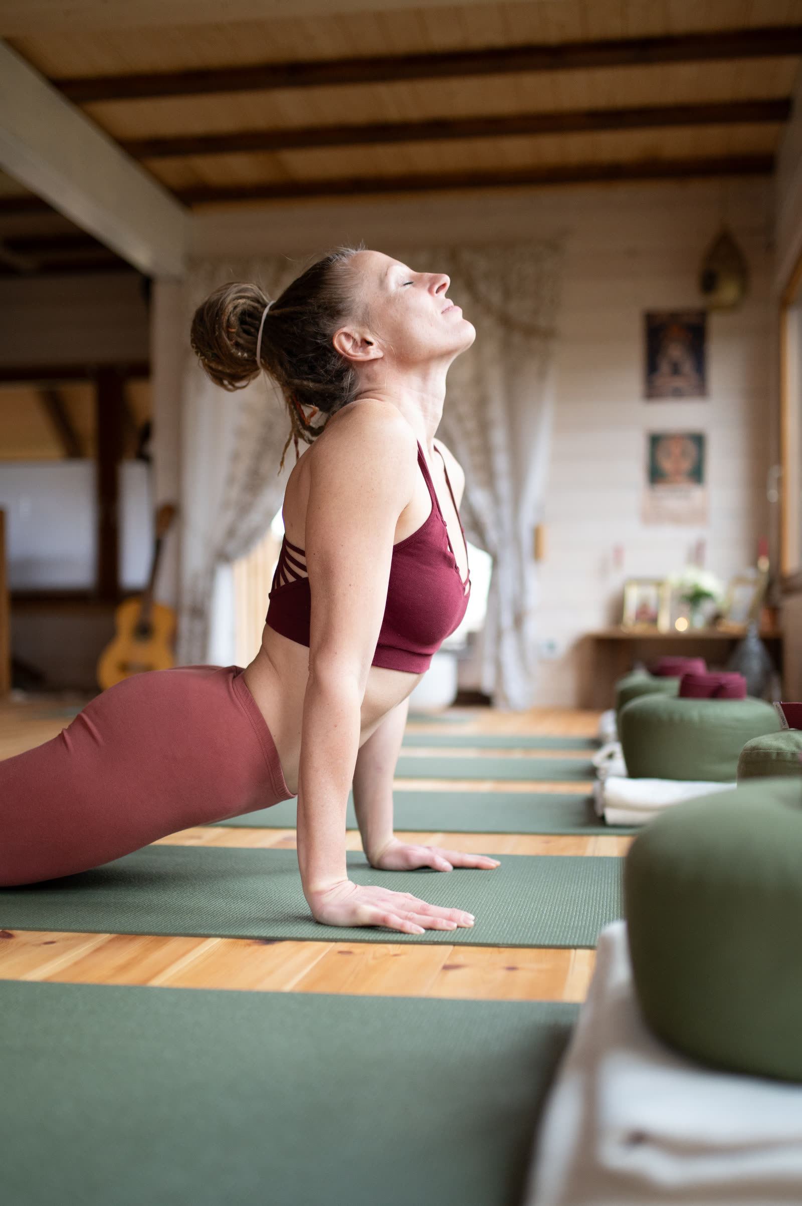 Lydia in der Kobra auf der Matte im Yogaraum, die Augen geschlossen