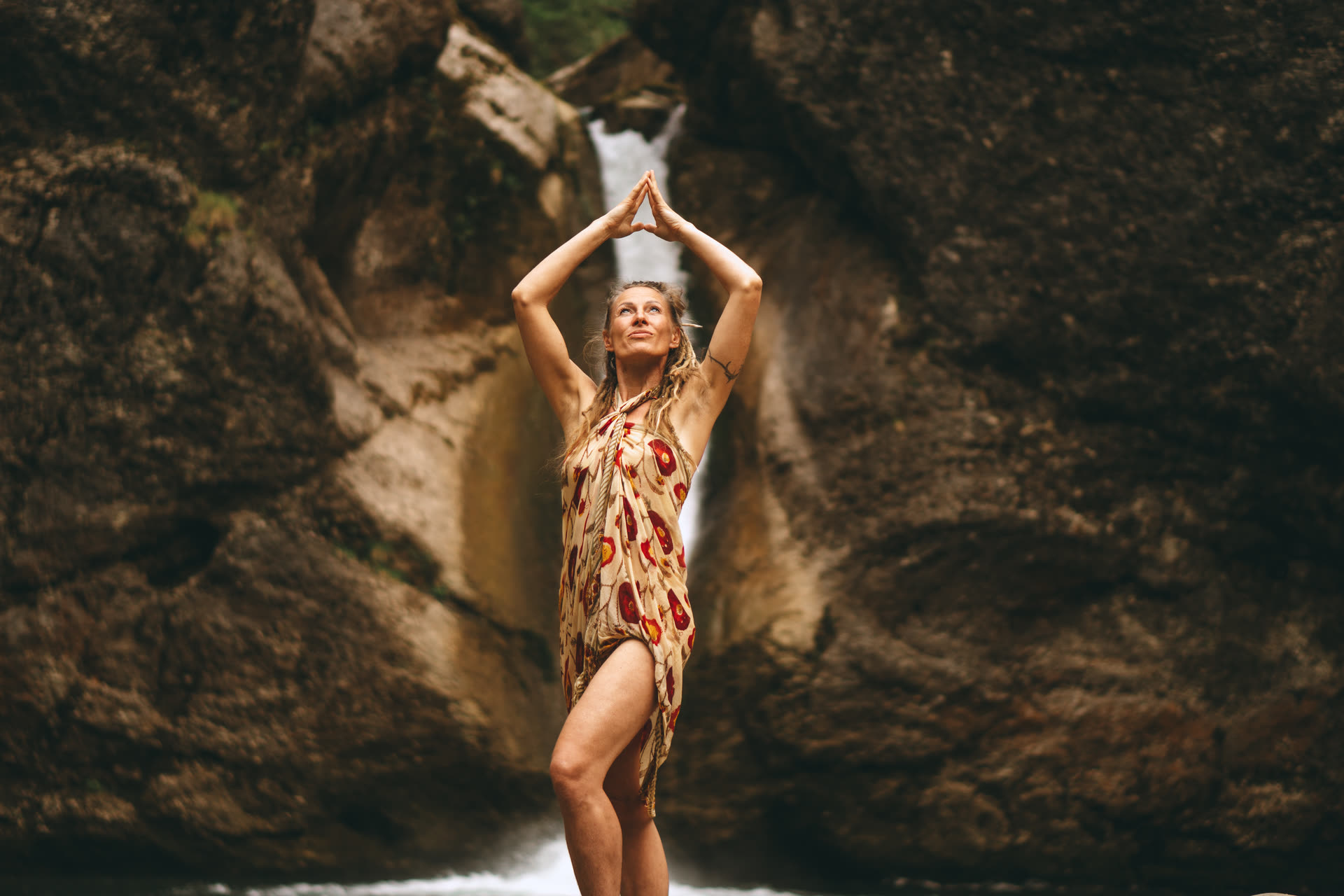 Lydia in einer Yogahaltung an einem Wasserfall